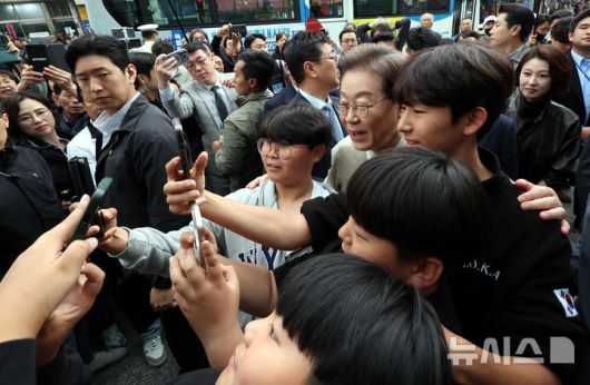 [옥천=뉴시스] 조성봉 기자 = 민심을 청취하는 '경청 투어'에 나선 이재명 더불어민주당 대선후보가 6일 충북 옥천군 옥천공설시장에서 어린이들과 셀카를 찍고 있다. 2025.05.06. suncho21@newsis.com