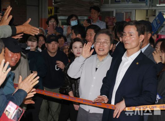 [임실=뉴시스] 조성봉 기자 = 민심을 청취하는 '경청 투어'에 나선 이재명 더불어민주당 대선후보가 7일 전북 임실군 임실전통시장에서 시민들에게 인사를 하고 있다. (공동취재) .2025.05.07. photo@newsis.com