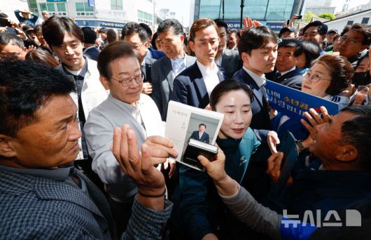 [임실=뉴시스] 조성봉 기자 = 민심을 청취하는 '경청 투어'에 나선 이재명 더불어민주당 대선후보가 7일 전북 임실군 임실전통시장에서 시민들에게 사인 요청을 받고 있다. (공동취재) .2025.05.07. photo@newsis.com