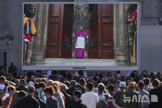[바티칸=AP/뉴시스] 7일(현지 시간) 바티칸 성베드로 대성당 앞 대형스크린에 제267대 교황을 선출하는 콘클라베를 시작하기 위해 디에고 조반니 라벨리 대주교가 문을 닫는 모습이 생중계 되고 있다. 2025.05.08.