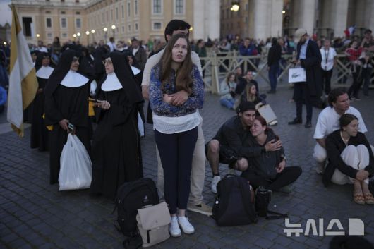 [바티칸=AP/뉴시스] 7일(현지 시간) 바티칸 시국 성 베드로 광장에 모인 사람들이 시스티나 성당 굴뚝에서 교황 선출 여부를 알리는 연기가 피어오르기를 기다리고 있다. 이날 제267대 교황을 선출하는 추기경들의 비밀회의 ‘콘클라베’ 첫 투표가 실시됐으며, 교황이 선출되지 않으면 굴뚝에서 검은 연기가, 선출되면 흰 연기가 피어올라 결과를 알린다. 2025.05.08.