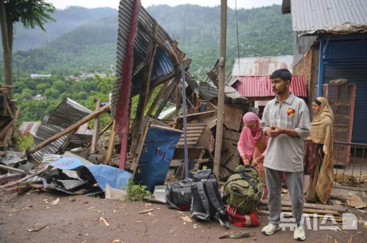 [우리=AP/뉴시스] 지난 9일(현지 시간) 인도령 카슈미르 우리 지역 긴갈 마을에서 한 가족이 밤사이 파키스탄의 포격을 받은 마을을 떠나며 대중교통을 기다리고 있다. 2025.05.10.