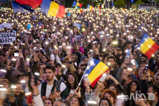 [부쿠레슈티=AP/뉴시스] 11일(현지 시간) 루마니아 부쿠레슈티에서 열린 니쿠쇼르 단 대선 후보 유세 현장에서 지지자들이 휴대전화 플래시를 밝히며 응원하고 있다.  2025.05.19.