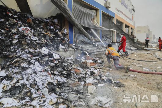Libyan firefighters put out a fire at a book store at the clashes site between heavily armed militias in Tripoli, Libya, Wednesday, May 14, 2025. (AP Photo/Yousef Murad)