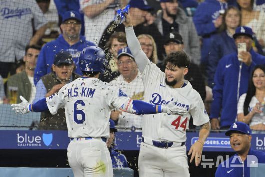 [로스앤젤레스=AP/뉴시스] LA 다저스의 김혜성(왼쪽)이 지난 14일(현지 시간) 미 캘리포니아주 로스앤젤레스의 다저스타디움에서 열린 2025 메이저리그 오클랜드 애슬레틱스와의 경기 5회 말 동점을 기록하는 1점 홈런(시즌 1호)을 친 후 더그아웃에서 해바라기씨 세례를 받고 있다. 2025.05.15.