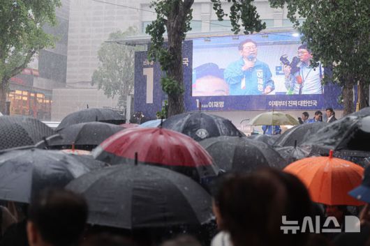 [순천=뉴시스] 권창회 기자 = 15일 전남 순천시 연향동 패션의거리에서 열린 이재명 더불어민주당 대선 후보의 유세에서 시민들이 폭우 속에도 이 후보의 연설을 듣고 있다. 2025.05.15. kch0523@newsis.com