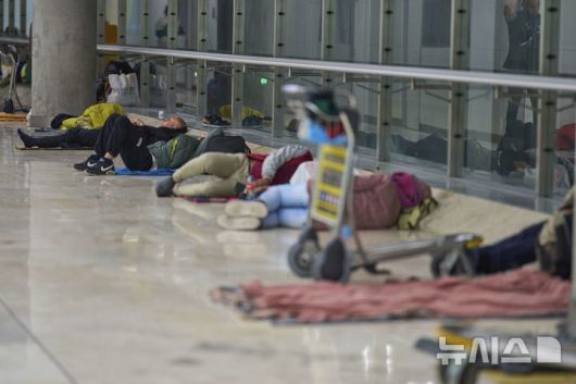 [마드리드=AP/뉴시스] 15일(현지 시간) 스페인 마드리드의 아돌포 수아레스 마드리드-바라하스 공항 4터미널 바닥에서 사람들이 잠을 자고 있다. 공항 당국은 터미널 내에 증가하는 노숙자 문제로 일부 시간대에 탑승권이 없는 사람들의 출입을 제한할 것으로 전해졌다. 2025.05.16.