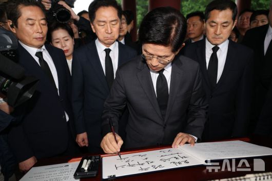 [광주=뉴시스] 조성봉 기자= 김문수 국민의힘 대통령 후보가 17일 오전 광주 북구 5.18민주묘지를 찾아 참배하기 전 방명록을 쓰고 있다. (공동취재) 2025.05.17. photo@newsis.com