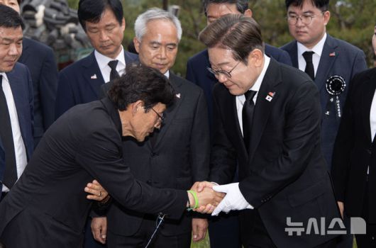 [광주=뉴시스] 조성우 기자 = 이재명 더불어민주당 대통령 후보가 17일 오전 광주 북구 5·18 민주묘지를 찾아 김동수 열사 묘역에 헌화한 후 유족을 위로하고 있다. (공동취재) 2025.05.17. photo@newsis.com