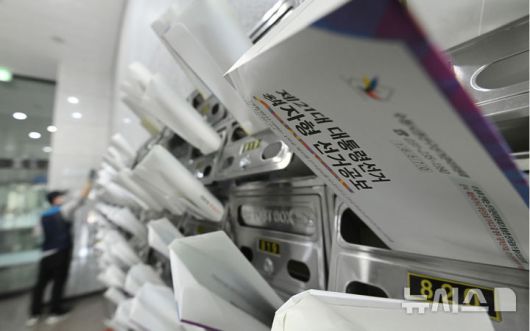 [수원=뉴시스] 김종택 기자 = 18일 경기 수원시 권선구 한 오피스텔 건물에서 우체국 집배원이 제21대 대통령선거 안내문과 선거공보물을 우편함에 넣고 있다. 2025.05.18. jtk@newsis.com