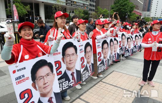 [서울=뉴시스] 고승민 기자 = 김문수 국민의힘 대선 후보가 19일 서울 청계광장에서 청년정책 발표를 하는 동안 선거운동원들이 환호하고 있다. 2025.05.19. kkssmm99@newsis.com