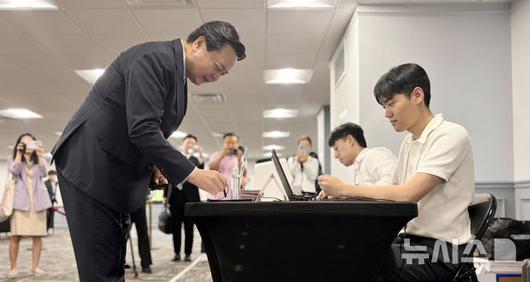 [워싱턴=뉴시스]이윤희 특파원 = 20일(현지 시간) 미국 버지니아주 알렉산드리아 코리안커뮤니티센터에 마련된 제21대 대통령선거 재외투표 투표소에서 조현동 주미대사가 본인 확인을 하고 있다. 이번 대선 재외선거는 이날부터 오는 25일까지 전 세계 118개국 223개 투표소에서 진행된다. 2025.05.21. sympathy@newsis.com