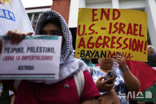 [케손시티=AP/뉴시스]  필리핀 케손시티에서 23일 친팔레스타인 시위대가 이스라엘의 가자지구 공습을 규탄하는 손팻말을 들고 시위하고 있다. 2025.05.26.