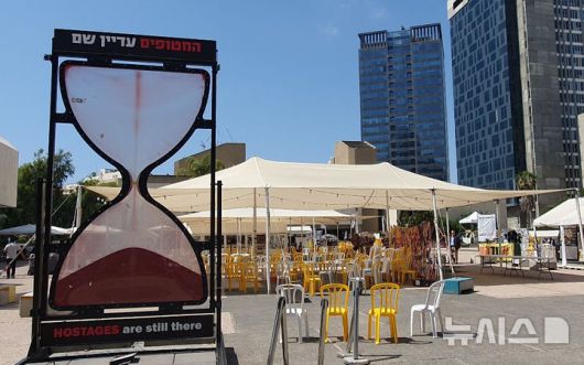 [텔아비브=뉴시스]김난영 기자 = 22일(현지 시간) 이스라엘 텔아비브 소재 인질 광장에 억류 시간을 뜻하는 모래시계와 인질의 자리를 뜻하는 노란색 의자가 놓여 있다. 2025.05.25.