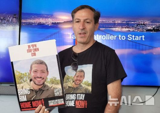 [텔아비브=뉴시스]김난영 기자 = 하마스 잔여 억류 인질인 이타이 헨의 부친 루비 헨 씨가 22일(현지 시간) 텔아비브 인질가족포럼 본부에서 아들의 사진을 들고 있다. 2025.05.25.