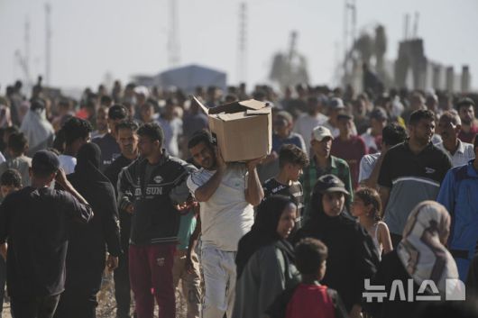 [라파(가자지구)=AP/뉴시스]가자지구 남부 라파에서 27일 이스라엘의 승인을 받은 미국 지원 가자인도주의재단 앞에 구호품을 받으려는 팔레스타인인들이 몰려들었다. 구호센터에 군중들이 몰리면서 47명이 부상했으며, 대부분은 이스라엘군 총격에 의한 것이라고 한  유엔 팔레스타인인권사무소의 아지트 숭하이 대표가 말했다. 2025.06.01.