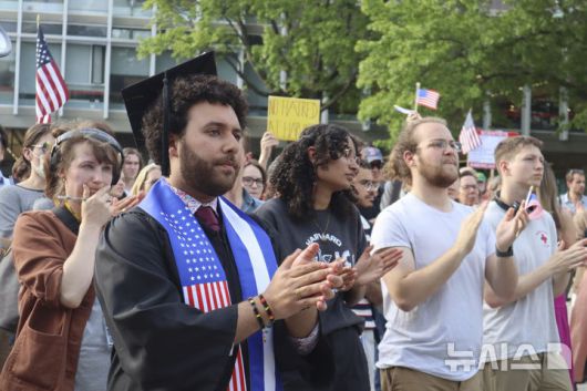 [케임브리지=AP/뉴시스] 하버드대 졸업생인 빅터 플로레스를 비롯한 학생들이 지난 27일(현지 시간) 한 학생의 연설에 손벽을 치고 있다. 이날 수백 명의 학생이 교내에서 열린 반트럼프 시위에 참가했다. 2025.05.29.