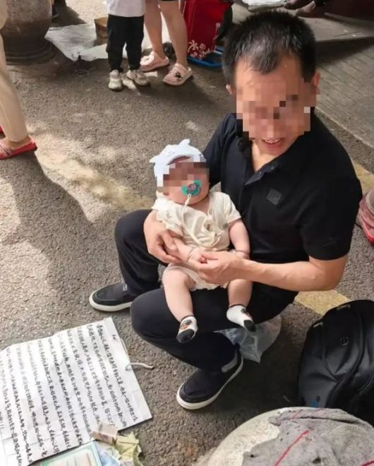 [서울=뉴시스]최근 중국 충칭시 바난구에서 한 남성이 아기를 품에 안고 "아내를 찾는다"며 길거리에서 호소하는 모습이 화제를 모았다.(사진=대완신문) *재판매 및 DB 금지
