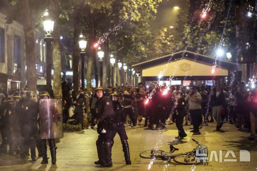 [파리=AP/뉴시스] 프랑스 프로축구 파리 생제르맹(PSG)의 유럽축구연맹(UEFA) 챔피언스리그(UCL) 첫 우승을 자축하는 과정에서 전국 곳곳에서 폭력과 소요가 발생해 최소 2명이 숨지고 500여명이 체포됐다. 사진은 지난 31일(현지 시간) 프랑스 파리의 샹젤리제 거리에서 경찰들이 팬들이 쏜 폭죽을 피하는 모습. 2025.06.02