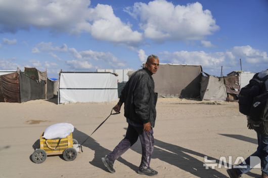 [칸유니스=AP/뉴시스] 3일(현지 시간) 가자지구 칸유니스에서 한 주민이 구호품을 받고 돌아가고 있다. 2025.06.04.