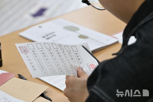 [광주=뉴시스] 이영주 기자 = 제21대 대통령 선거 본투표날인 3일 오전 광주 서구 금호중학교에 마련된 금호1동 제2투표소에서 선거사무원이 유효한 투표용지를 준비하고 있다. 2025.06.03. leeyj2578@newsis.com