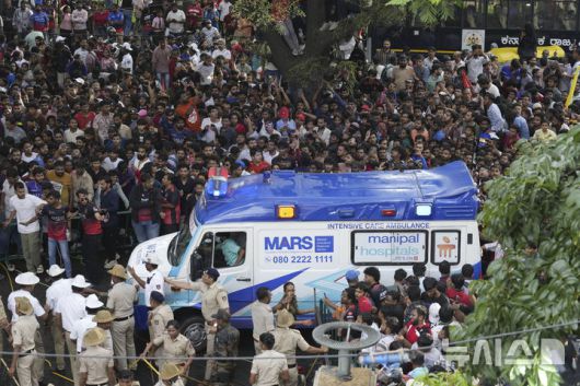 [벵갈루루=AP/뉴시스] 4일(현지 시간) 인도 카르나타카주 벵갈루루의 M. 치나스와미 경기장에서 크리켓 인디언 프리미어리그(IPL) '로열 챌린저스 벵갈루루'의 우승 축하 행사가 열려 팬들이 몰려든 가운데 구급차 한 대가 도착하고 있다. 이날 행사에 수많은 인파가 몰려 최소 11명이 숨지고 30여 명이 다치는 압사 사고가 발생했다. 2025.06.05.