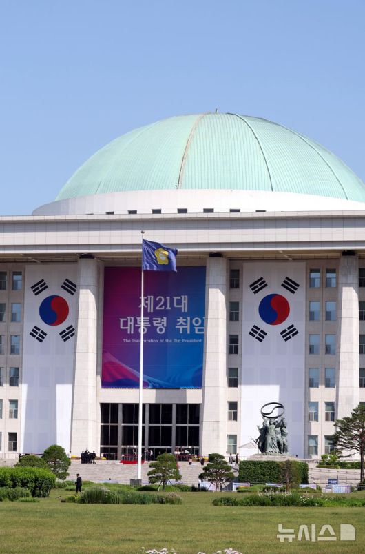 [서울=뉴시스] 조성봉 기자 = 이재명 제21대 대통령 취임선서식이 열리는 4일 오전 서울 여의도 국회 본청 외벽에 대형 태극기와 행사 현수막이 걸려 있다.  2025.06.04. suncho21@newsis.com