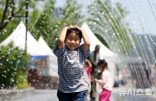 [서울=뉴시스] 홍효식 기자 = 서울 낮 최고기온이 28도까지 오른 지난 6일 서울 종로구 광화문광장 분수대에서 한 어린이가 물놀이를 하고 있다. 2025.06.06. yesphoto@newsis.com