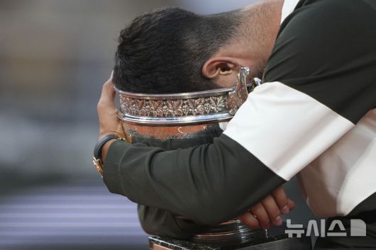 [파리=AP/뉴시스] 카를로스 알카라스(2위·스페인)가 8일(현지 시간) 프랑스 파리 롤랑가로스에서 열린 프랑스오픈 남자 단식 정상에 올라 트로피에 얼굴을 파묻고 기뻐하고 있다. 알카라스는 결승전에서 얀니크 신네르(1위·이탈리아)와 5시간 29분 대접전 끝에 3-2(4-6 6-7 6-4 7-6 7-6) 역전승을 거두고 대회 2연패를 달성했다. 2025.06.09.