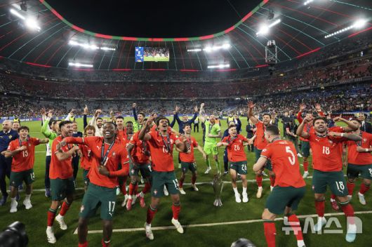 [뮌헨=AP/뉴시스] 포르투갈 선수들이 8일(현지 시간) 독일 뮌헨의 알리안츠 아레나에서 열린 2024-25 유럽축구연맹(UEFA) 네이션스리그(UNL) 스페인과의 결승전에서 승리해 우승한 후 트로피를 들고 환호하고 있다. 포르투갈은 연장까지 2-2 무승부를 기록해 승부차기 끝에 5-3으로 승리해 6년 만에 정상에 올랐다. 크리스티아누 호날두는 후반 16분 동점 골을 넣어 A매치 138호 골을 기록했다. 2025.06.09.