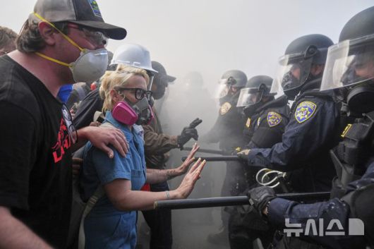 [로스앤젤레스=AP/뉴시스] 8일(현지 시간) 미 캘리포니아주 로스앤젤레스 도심 메트로폴리탄 구치소 인근 101번 고속도로에서 이민세관단속국(ICE)의 불법 이민자 단속 및 체포에 항의하는 시위대가 경찰과 대치하고 있다. 2025.06.09.