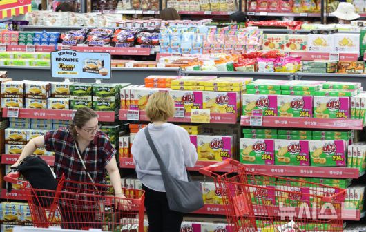 [서울=뉴시스] 황준선 기자 = 9일 서울 시내 한 대형마트에서 소비자들이 과자 등을 고르고 있다.통계청 국가통계포털(KOSIS)에 따르면 지난달 가공식품 74개 품목 가운데 윤석열 대통령의 비상계엄 사태 직전인 지난해 11월 대비 물가지수가 상승한 품목은 52개로 전체의 71.2%를 차지했다. 특히 초콜릿이 10.4%, 커피는 8.2% 상승했다. 양념 소스와 식초, 젓갈등도 7% 넘게 올랐다. 2025.06.09. hwang@newsis.com