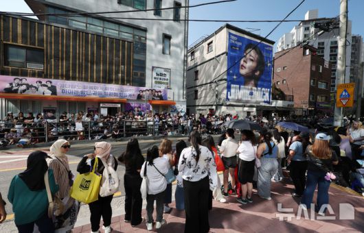 [서울=뉴시스] 김진아 기자 = 그룹 방탄소년단(BTS) 정국, 지민이 전역한 11일 서울 용산구 하이브 사옥 앞에서 BTS의 팬덤 '아미'(ARMY)들이 멤버들의 전역을 축하하고 있다. 2025.06.11. bluesoda@newsis.com