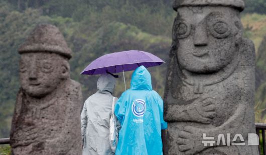 [서귀포=뉴시스] 우장호 기자 = 올해 첫 장맛비가 내리는 지난 12일 오전 제주 서귀포시 대정읍 송악산 둘레길에서 우산을 쓴 관광객들이 걸어가고 있다. 2025.06.12. woo1223@newsis.com