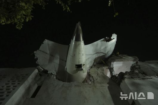 [아마다바드=AP/뉴시스] 12일(현지 시간) 인도 구자라트주 아마다바드에서 발생한 여객기 추락 사고 현장에 비행기 꼬리 부분이 건물에 박혀 있다. 이날 오후 아마다바드 공항에서 이륙한 영국행 에어인디아 AI171편 여객기가 추락해 탑승자 242명 가운데 1명을 제외한 전원이 숨졌으며, 추락 현장의 학생 등 약 50명도 사망한 것으로 전해졌다. 2025.06.13.