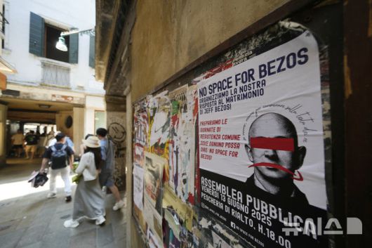 [베니스=AP/뉴시스] 지난 12일(현지 시간) 이탈리아 베니스의 한 건물 외벽에 아마존 창립자 제프 베이조스 초호화 결혼식을 비판하는 전단이 붙어 있다. 2025.06.26.