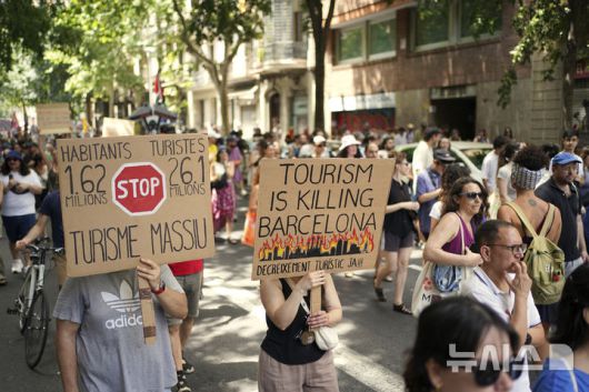 [바르셀로나=AP/뉴시스] 15일(현지 시간) 스페인 바르셀로나에서 오버투어리즘(과잉 관광)에 항의하는 시위가 열리고 있다. 2025.06.16.