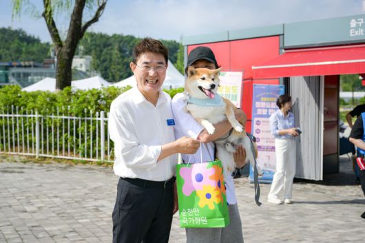 [순천=뉴시스] 15일 전남 순천시 순천만국가정원에서 펫데이 이벤트가 열린 가운데 노관규 순천시장이 반려견을 데리고 온 시민과 사진촬영하고 있다. (사진=순천시 제공) 2025.06.15. photo@newsis.com *재판매 및 DB 금지