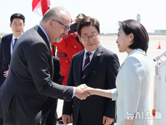[캘거리=뉴시스] 최진석 기자 = 주요 7개국(G7) 정상회의에 참석하는 이재명 대통령이 16일(현지 시간) 캐나다 앨버타주 캘거리국제공항에 도착한 가운데 김혜경 여사가 영접인사와 악수하고 있다. 2025.06.17. myjs@newsis.com