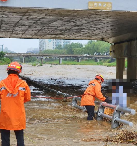 [전주=뉴시스] 21일 오후 4시5분께 전북 전주시 덕진구 진북교 아래에서 자전거를 타고 지나던 20대 여성이 불어난 강물에 고립돼 소방대원이 구조 작업을 진행하고 있다. (사진=전북도소방본부 제공) 2025.06.21. photo@newsis.com *재판매 및 DB 금지