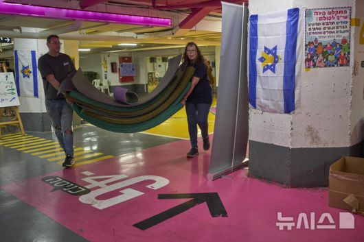 [텔아비브=AP/뉴시스] 24일(현지 시간) 이스라엘과 이란 간의 휴전이 발표된 후 텔아비브 지하 대피소에 대피했던 주민들이 매트리스를 걷어내고 있다. 2025.06.25.