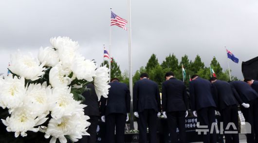 [부산=뉴시스] 하경민 기자 = '제75주년 6·25전쟁 참전 유엔전몰용사 추모제'가 열린 25일 부산 남구 유엔기념공원에서 참석자들이 전몰장병묘역에 헌화한 뒤 묵념을 하고 있다.유엔기념공원에는 총 14개국 2332명의 유엔군 전몰장병이 잠들어 있다. 2025.06.25. yulnetphoto@newsis.com