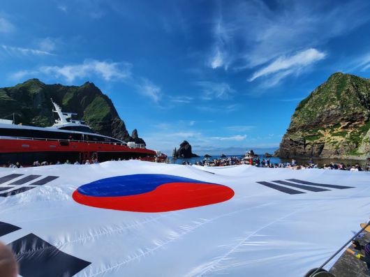 [서울=뉴시스]  독도의 동도 선착장 위를 덮는 초대형 태극기 (사진=서경덕 교수팀 제공) 2025.06.30. photo@newsis.com *재판매 및 DB 금지