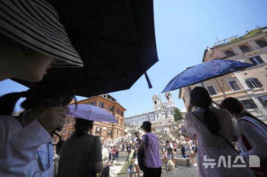 [로마=AP/뉴시스] 1일(현지 시간) 이탈리아 로마 스페인 광장을 찾은 관광객들이 양산으로 햇빛을 가리고 있다. 2025.07.02.