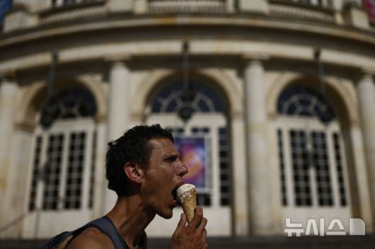 [렌=AP/뉴시스] 폭염이 이어진 1일(현지 시간) 프랑스 서부 렌에서 한 남성이 아이스크림을 먹고 있다. 2025.07.02.