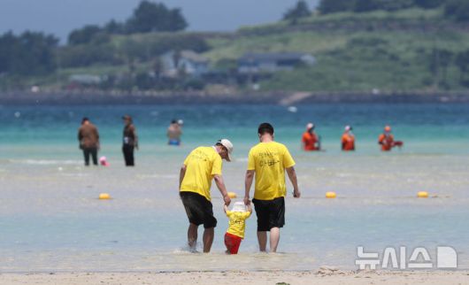 [제주=뉴시스] 우장호 기자 = 무더위가 기승을 부린 3일 오후 제주시 한림읍 금능해수욕장을 찾은 피서객들이 바닷물에 발을 담그며 더위를 식히고 있다. 기상청은 이날 제주 지역 장마가 사실상 지난달 26일 종료됐다고 발표했다. 올해 제주 장마 기간은 지난달 12~26일로 2주간이었으며, 이는 기상 관측 사상 가장 일찍 종료된 장마로 기록됐다. 2025.07.03. woo1223@newsis.com