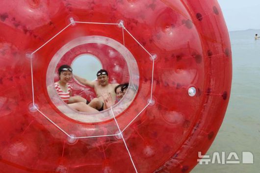 [원산=AP/뉴시스] 지난 2일 북한 강원도 원산의 원산-갈마 해안관광지구에서 사람들이 대형 물풍선을 타고 물놀이하고 있다. 북한 노동신문은 갈마관광지구 개장을 알리며 "세상에 없는 황홀한 관광 명소"라고 선전했다. 원산 명사십리 해변 일대에 조성된 관광지구 개발은 북한이 11년간 공들인 숙원사업으로 알려져 있다. 2025.07.04.