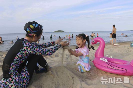 [원산=AP/뉴시스] 지난 1일 북한 강원도 원산의 원산-갈마 해안관광지구 해변에서 한 모녀가 모래 놀이를 하고 있다. 북한 노동신문은 갈마관광지구 개장을 알리며 "세상에 없는 황홀한 관광 명소"라고 선전했다. 원산 명사십리 해변 일대에 조성된 관광지구 개발은 북한이 11년간 공들인 숙원사업으로 알려져 있다. 2025.07.04.