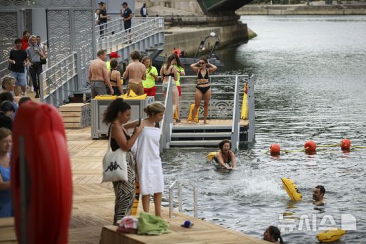 [파리=AP/뉴시스] 5일(현지 시간) 프랑스 파리 센 강에서 시민들이 수영을 하고 있다. 센 강은 100여 년 만에 공공 수영 공간으로 개방됐다. 마리 수로, 베르시 강변, 그르넬 항구 근처 등 세 곳이 야외 수영 구역으로 지정됐으며 오는 8월 31일까지 무료로 개방된다. 탈의실, 샤워 시설, 파라솔, 비치체어 등이 갖춰졌다. 2025.07.07.