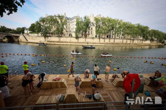 [파리=AP/뉴시스] 5일(현지 시간) 프랑스 파리 센 강에서 시민들이 수영을 하고 있다. 센 강은 100여 년 만에 공공 수영 공간으로 개방됐다. 마리 수로, 베르시 강변, 그르넬 항구 근처 등 세 곳이 야외 수영 구역으로 지정됐으며 오는 8월 31일까지 무료로 개방된다. 탈의실, 샤워 시설, 파라솔, 비치체어 등이 갖춰졌다. 2025.07.07.